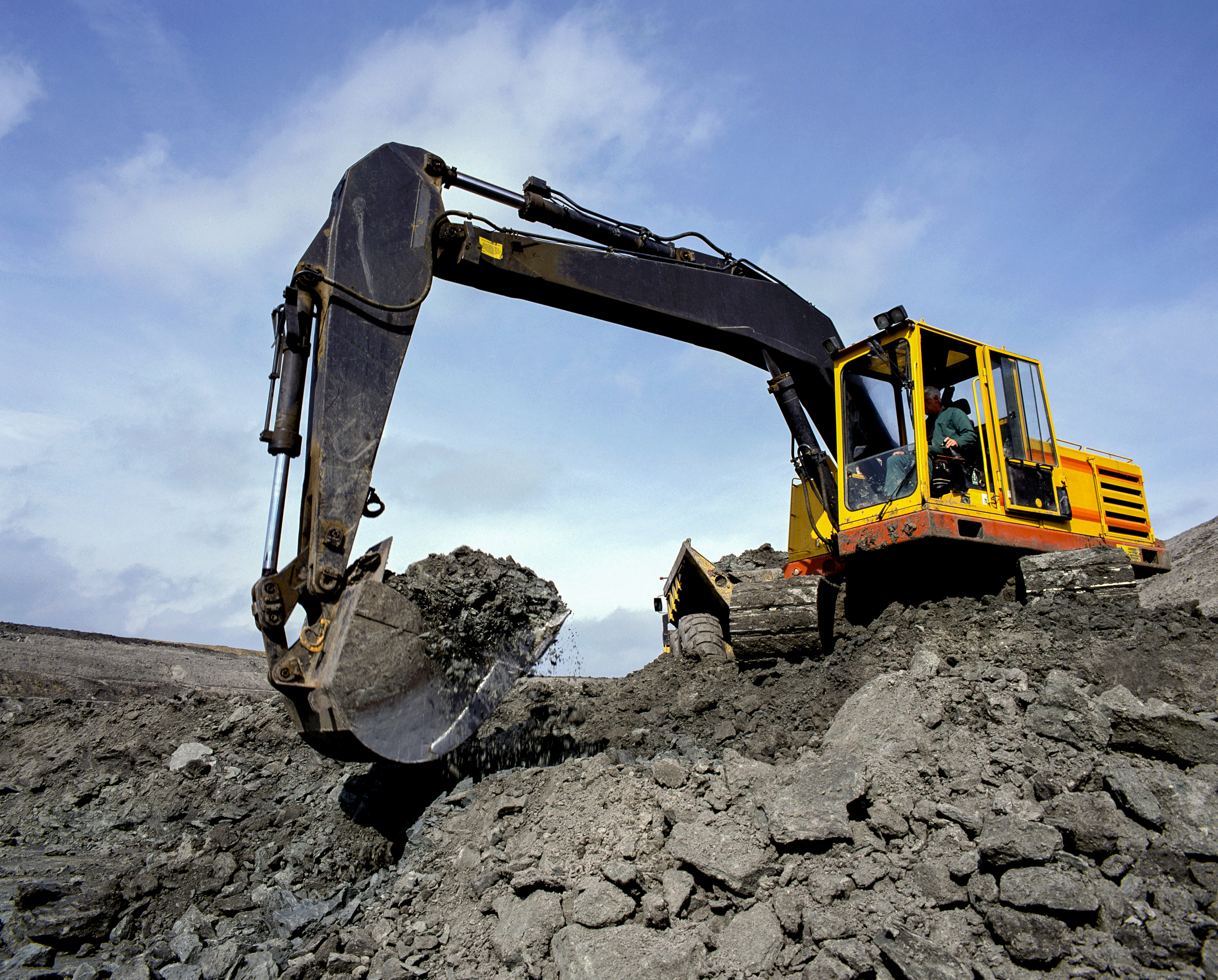 Excavator moving earth on a Macomb Contracting site