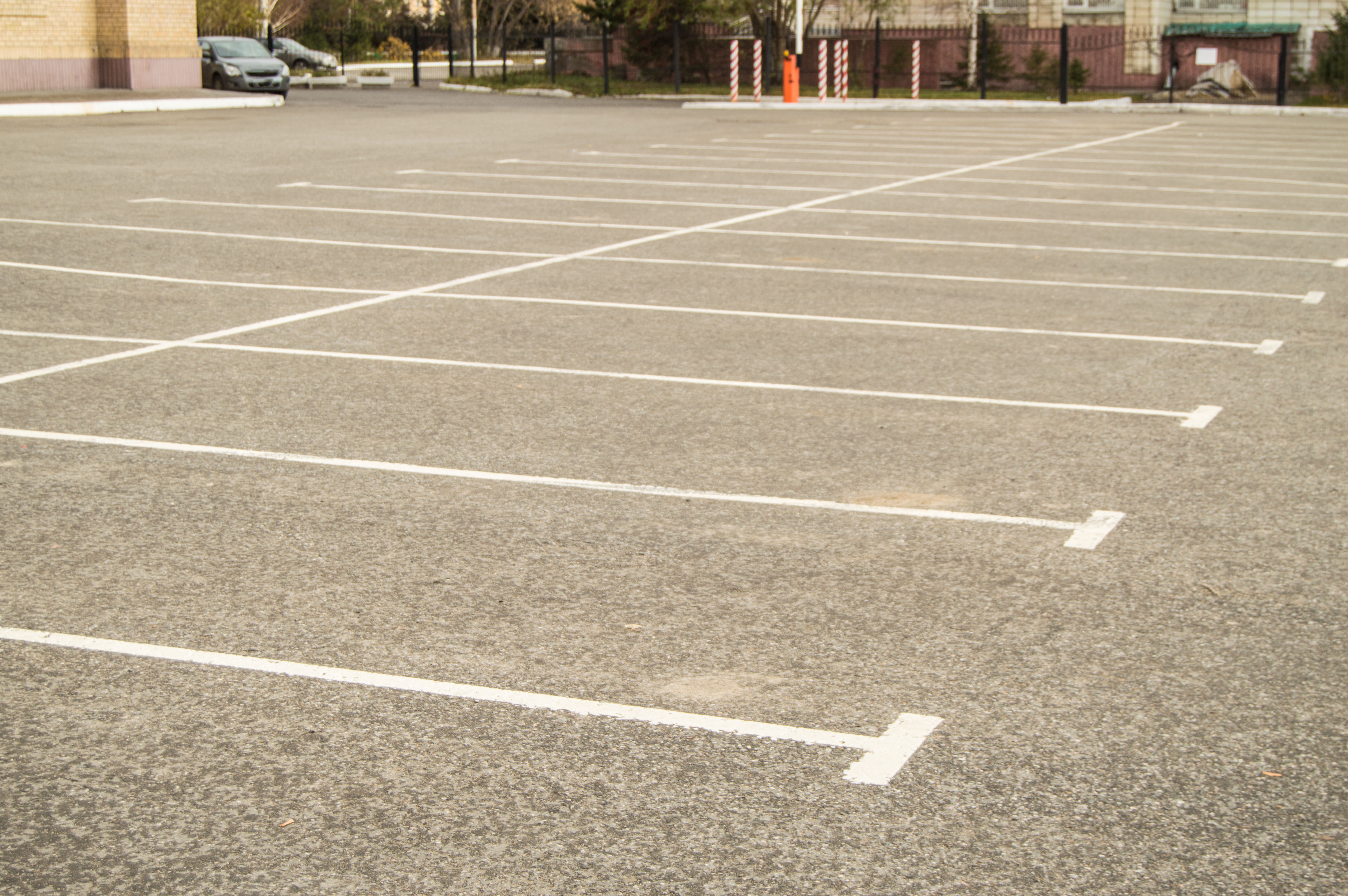 New commercial concrete parking lot with fresh striping and curbing, aerial angle
