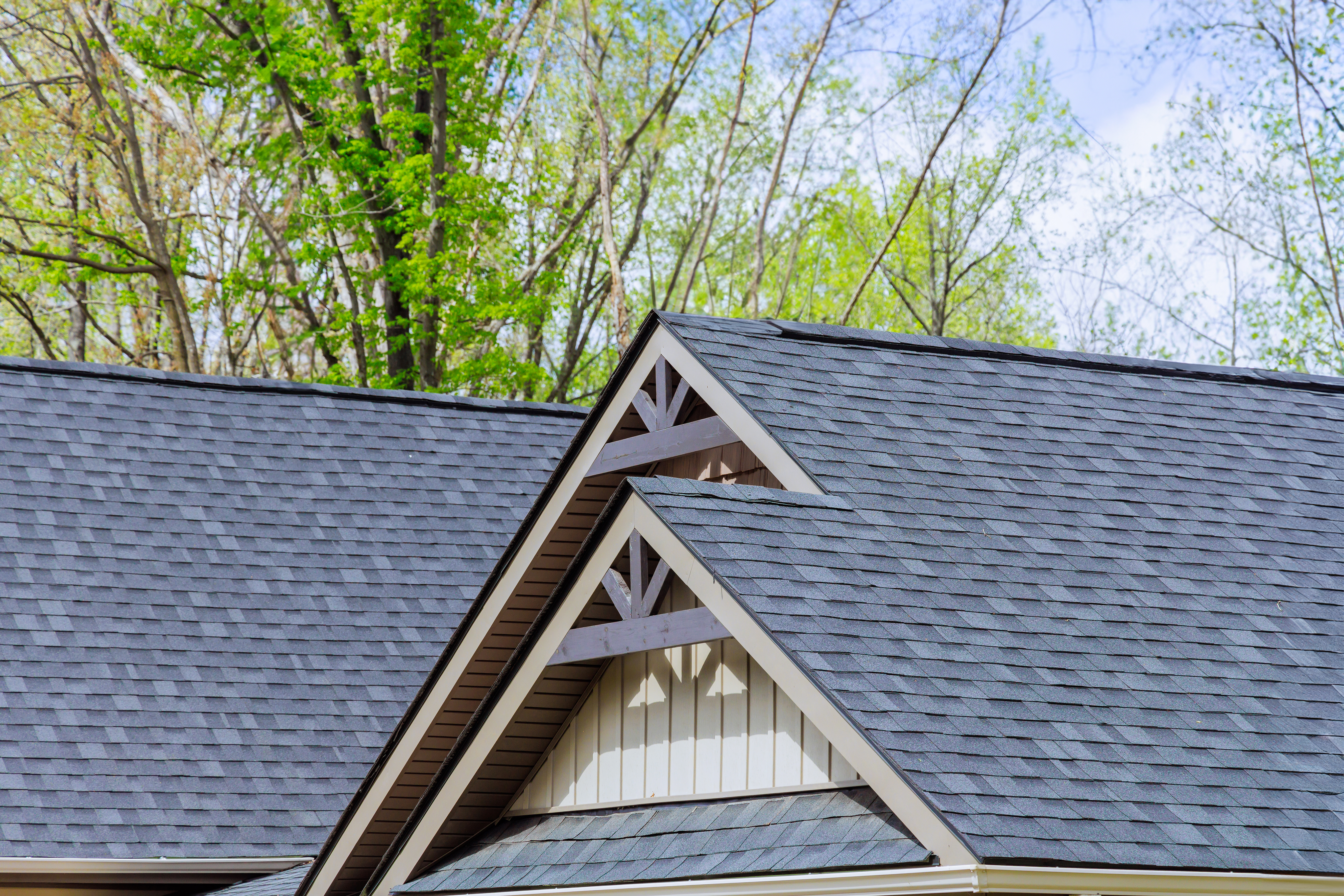 Completed architectural shingle roof on a large suburban home, clean lines