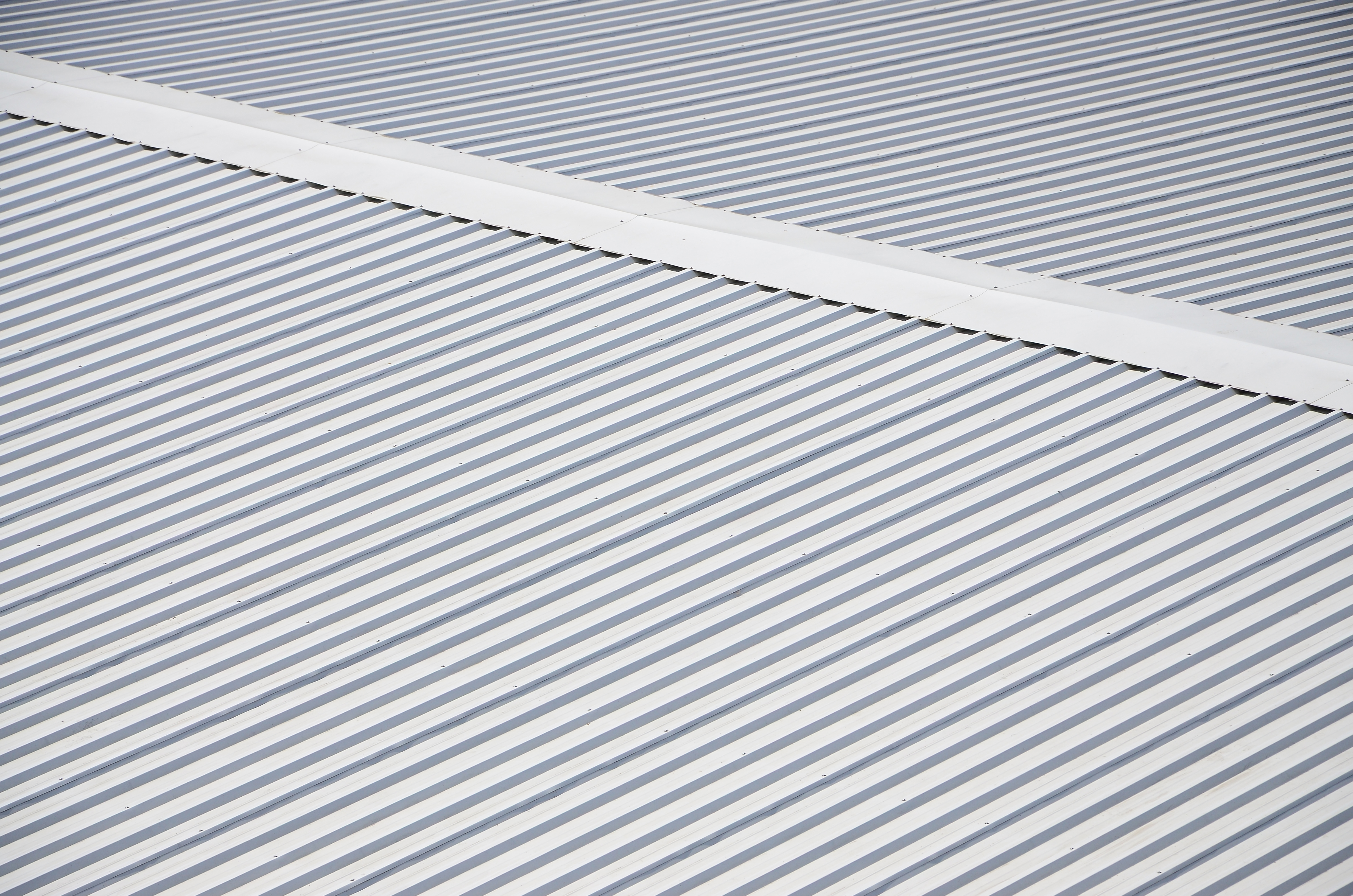 Newly completed white TPO commercial roof from above with rooftop mechanical units